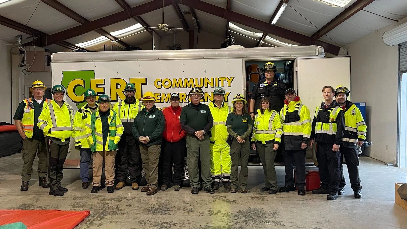 Group of Community Emergency Response Team members posing indoors in safety gear.